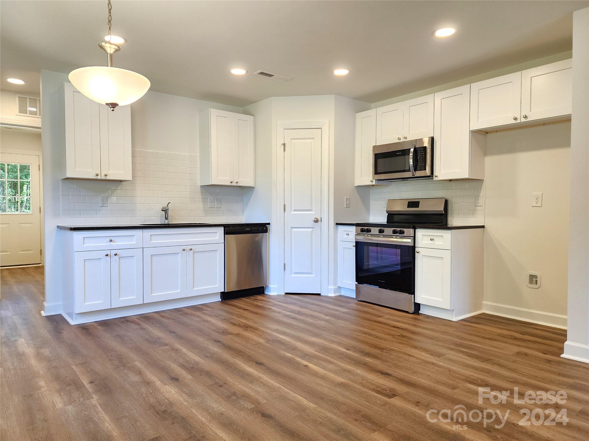 a kitchen with stainless steel appliances granite countertop a stove a sink and a refrigerator