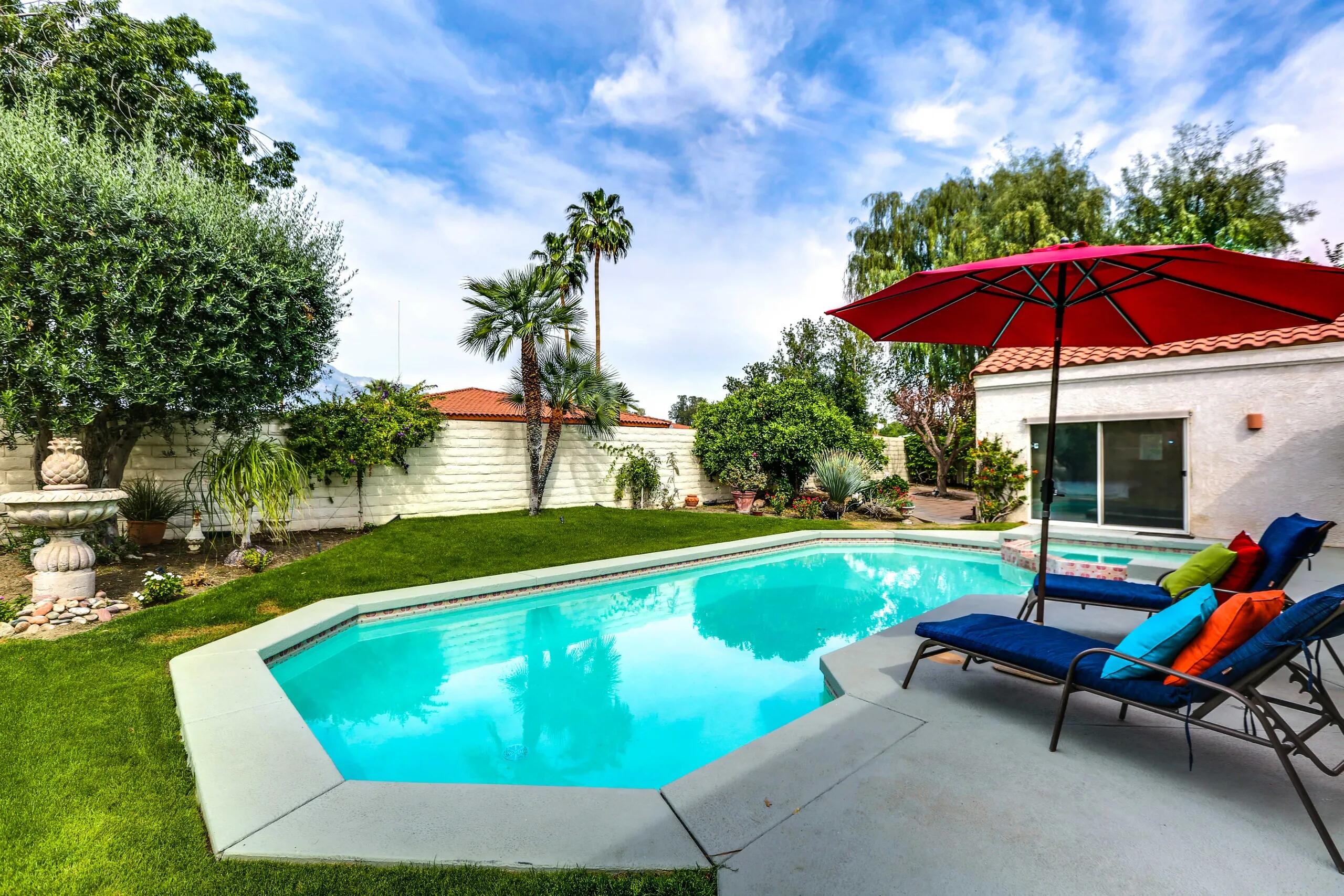 a view of a swimming pool with lounge chairs in patio