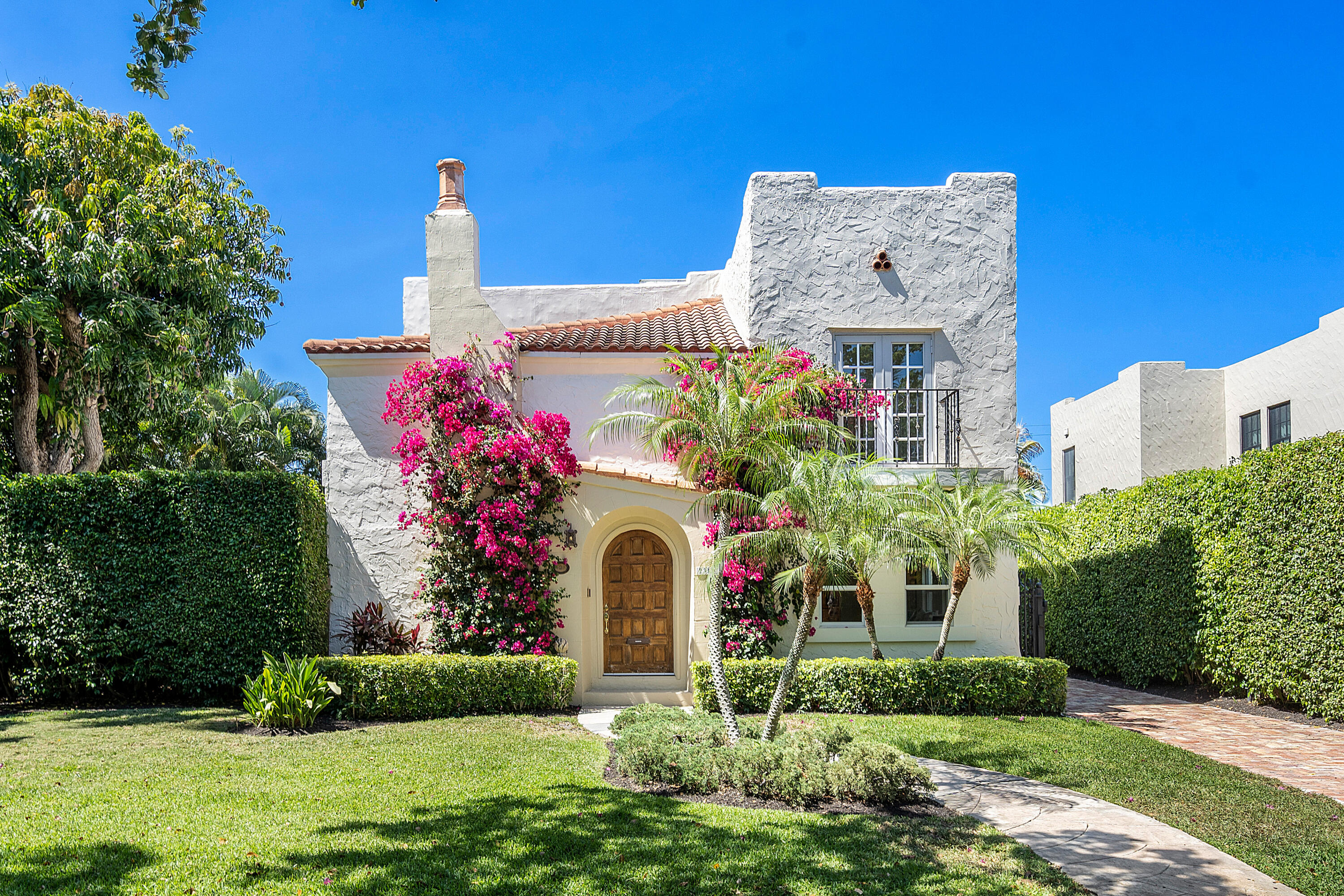 a front view of a house with a yard and fountain