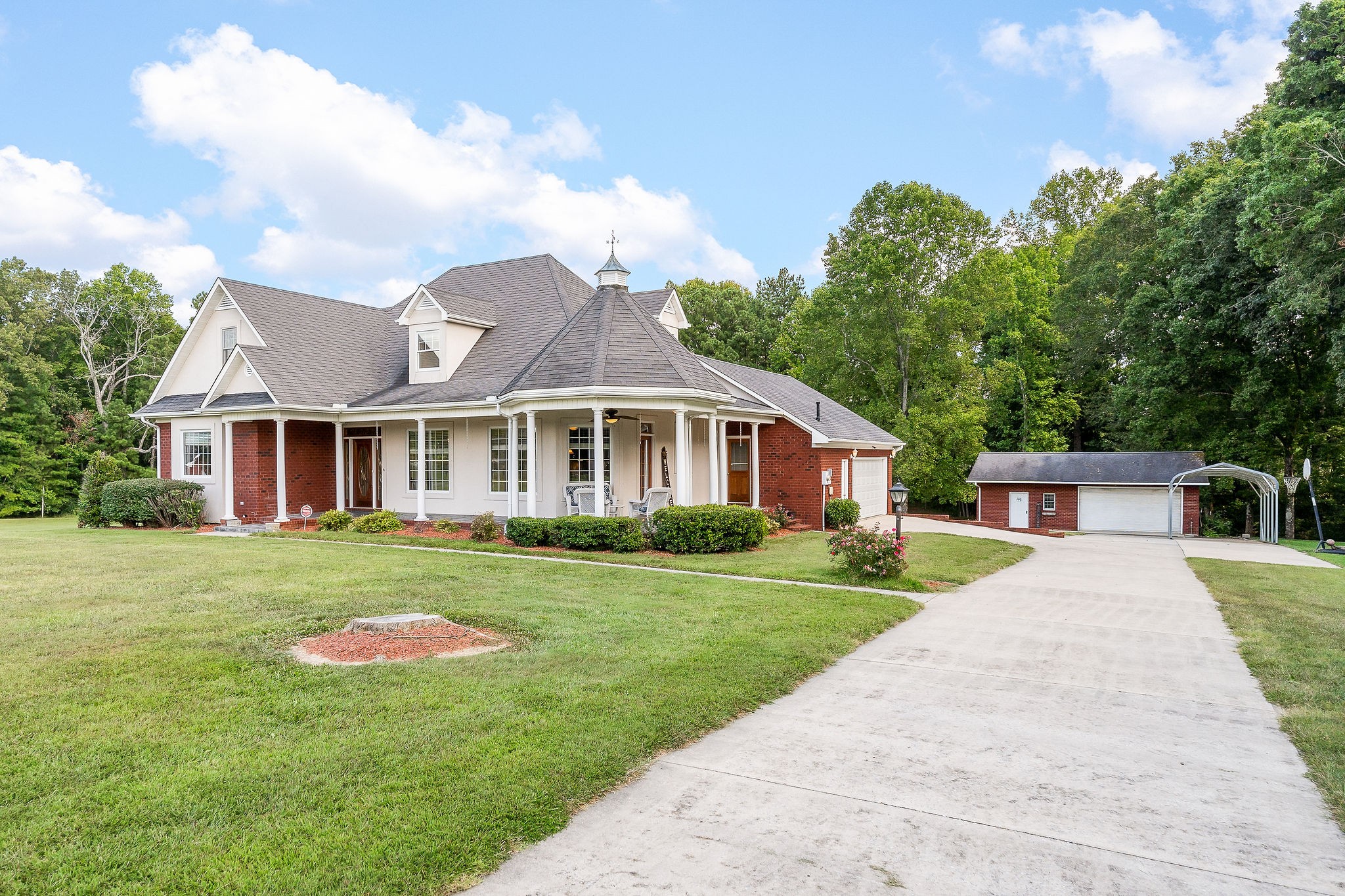 a front view of a house with a yard and trees