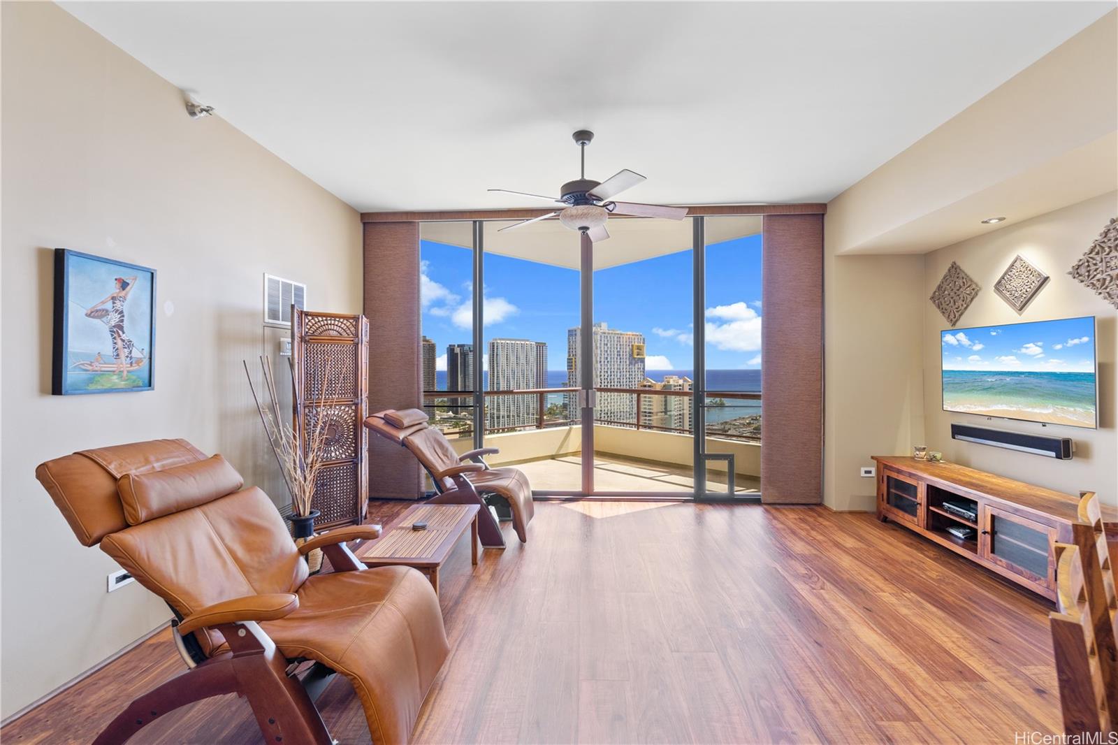 Spacious living room with views of the ocean and city lights.