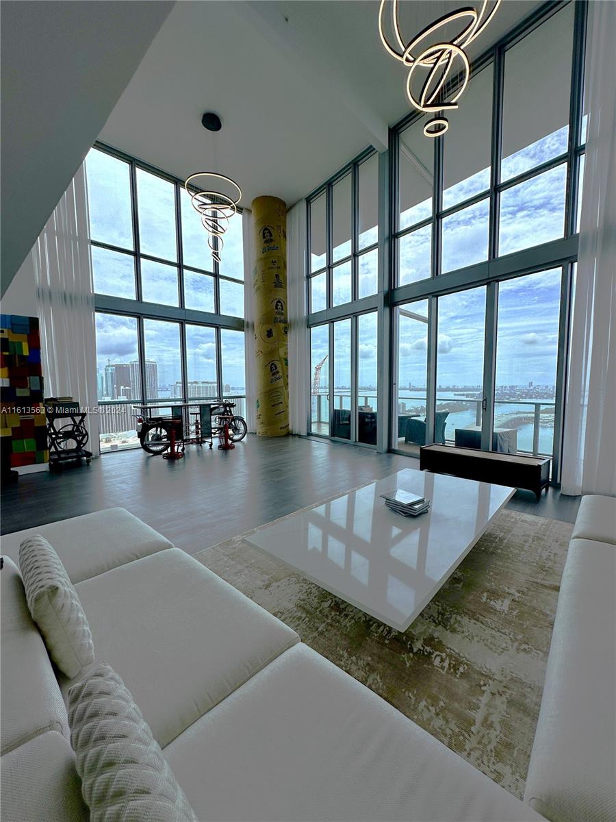 a living room with furniture and floor to ceiling windows