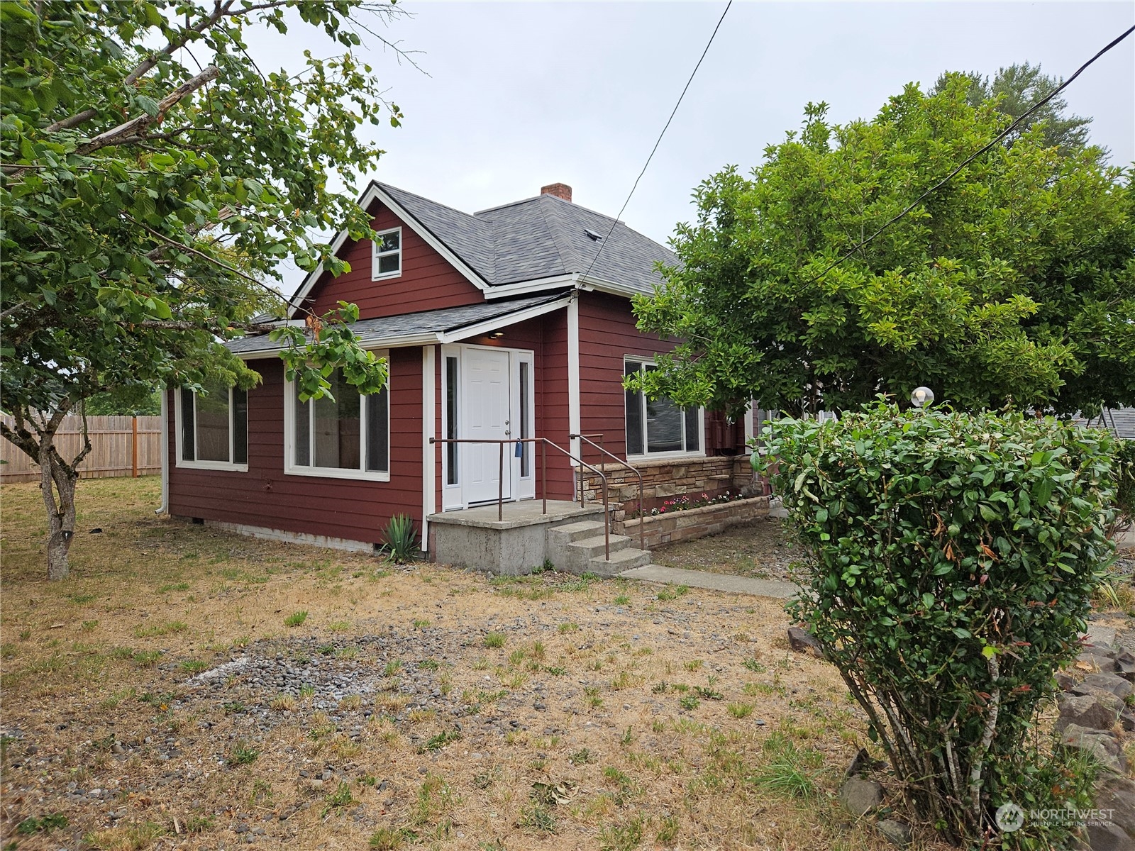 a view of a house with a yard and large tree