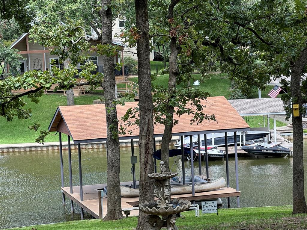 a front view of a house with a garden and lake view