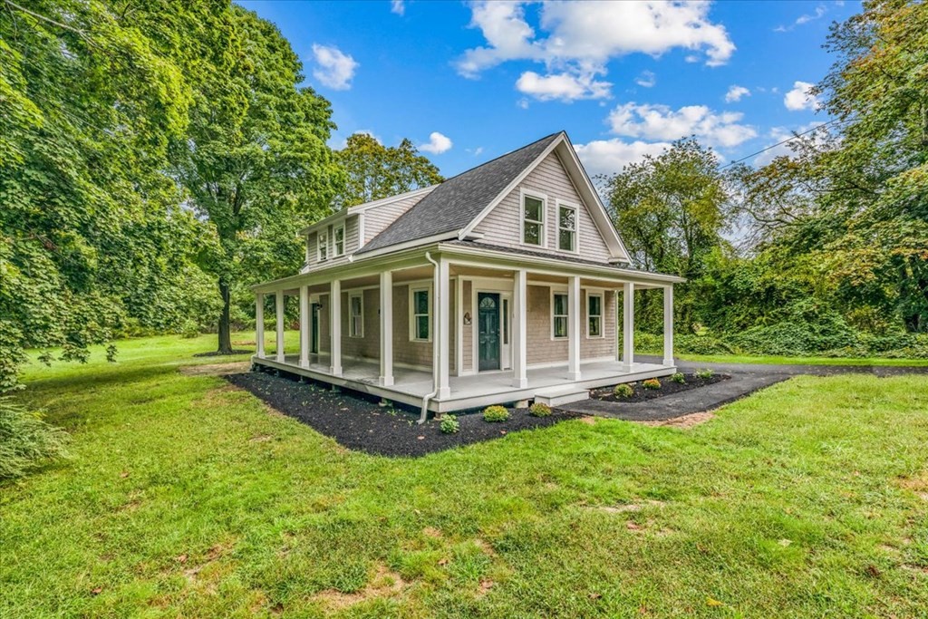 a view of a house with a yard and sitting area