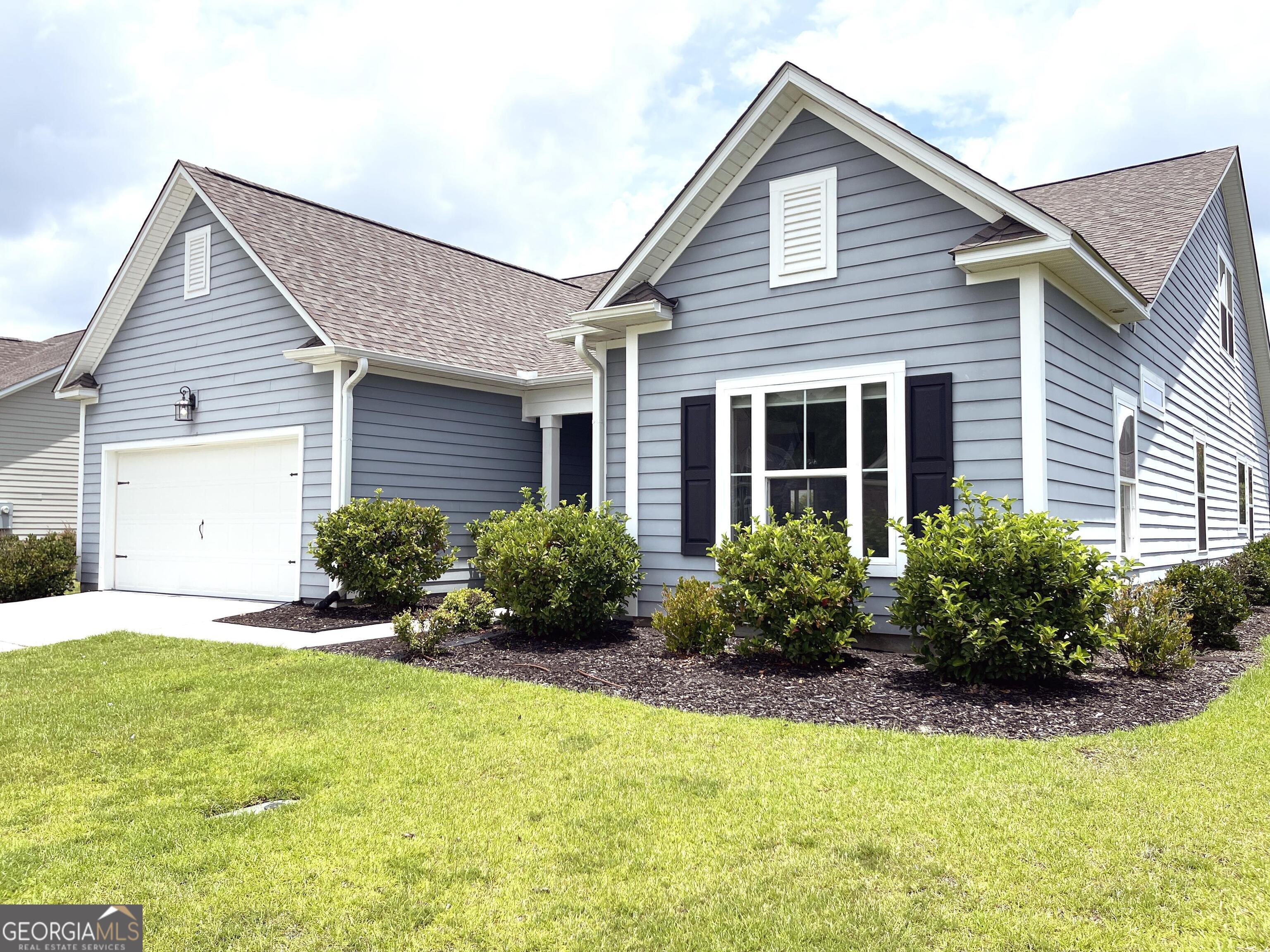 a front view of house with yard and green space