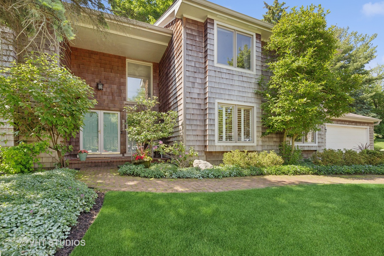 a front view of a house with a garden and plants