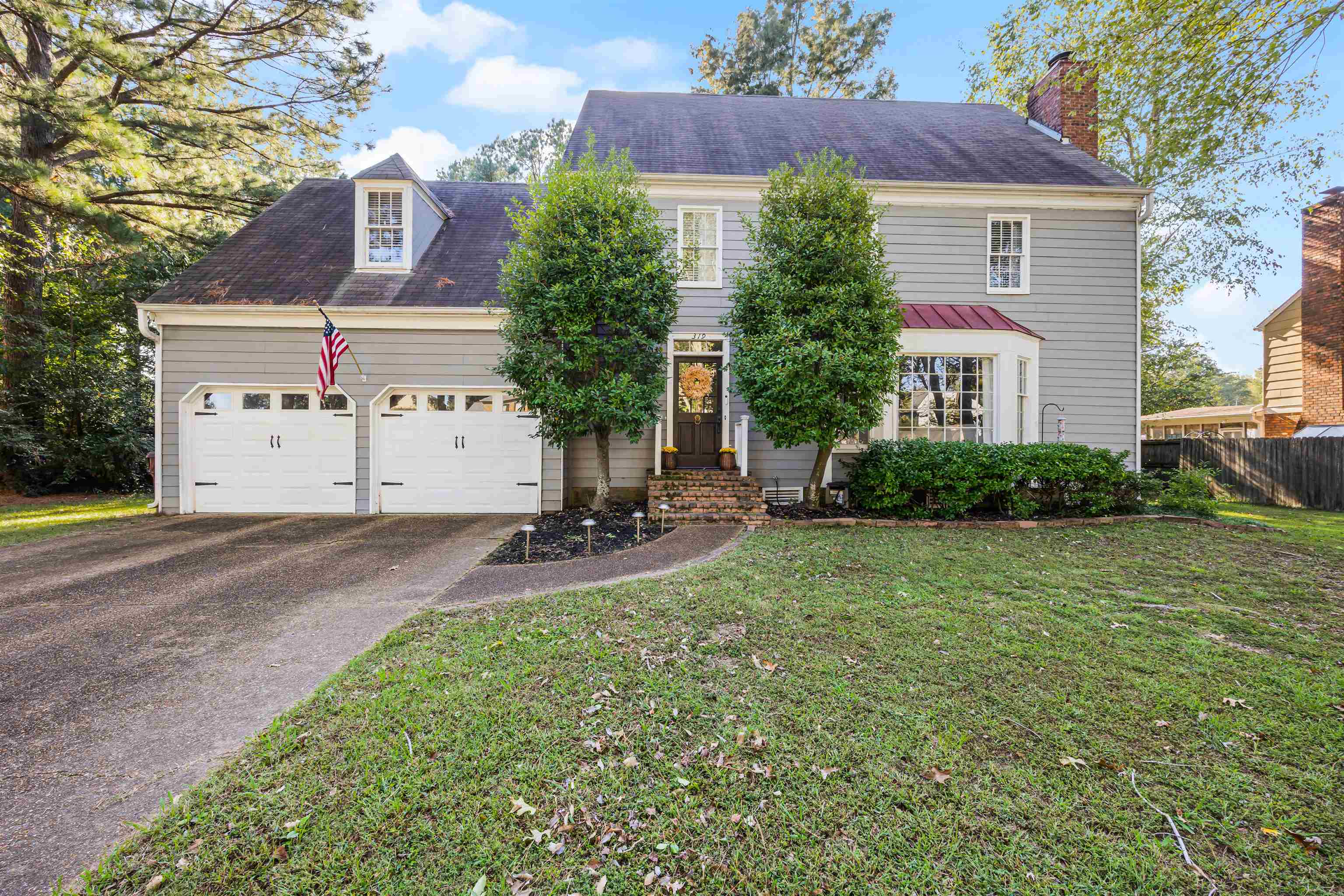 View of front of property featuring a garage and a front lawn