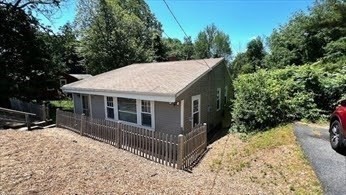 a view of a house with a yard and sitting area