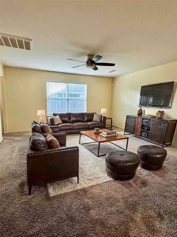 a living room with furniture a rug and a window