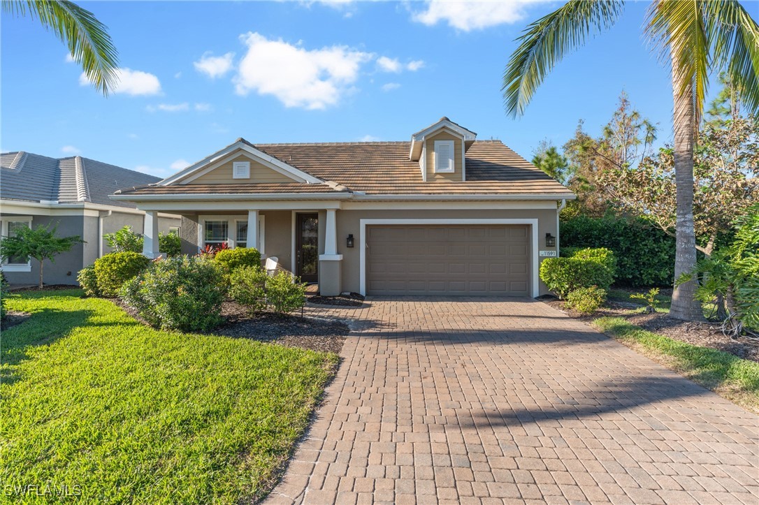 a front view of a house with a yard and potted plants