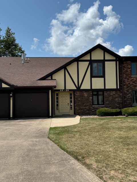 a front view of house with yard and garage