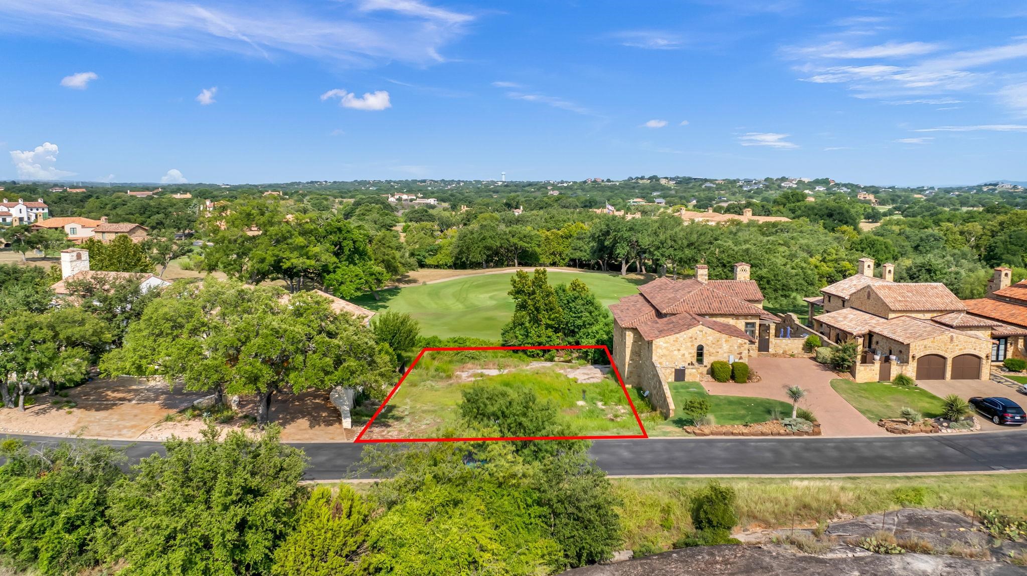 an aerial view of residential houses with outdoor space and trees