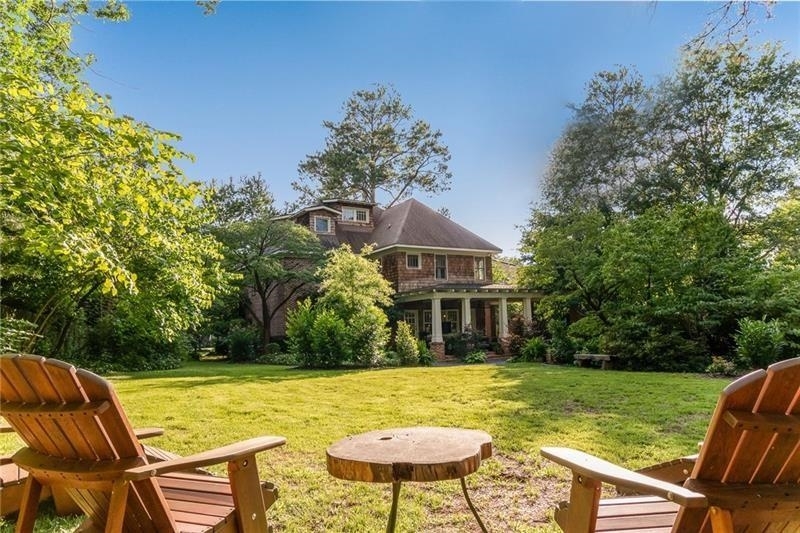 a view of house with swimming pool and outdoor seating