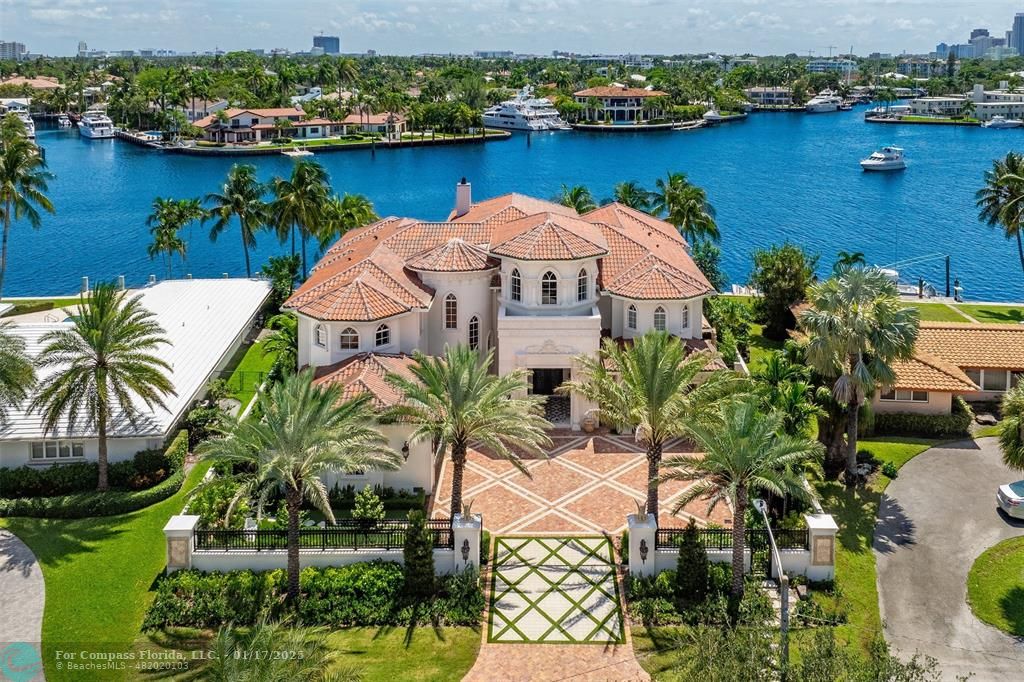 an aerial view of ocean and residential houses with outdoor space and seating