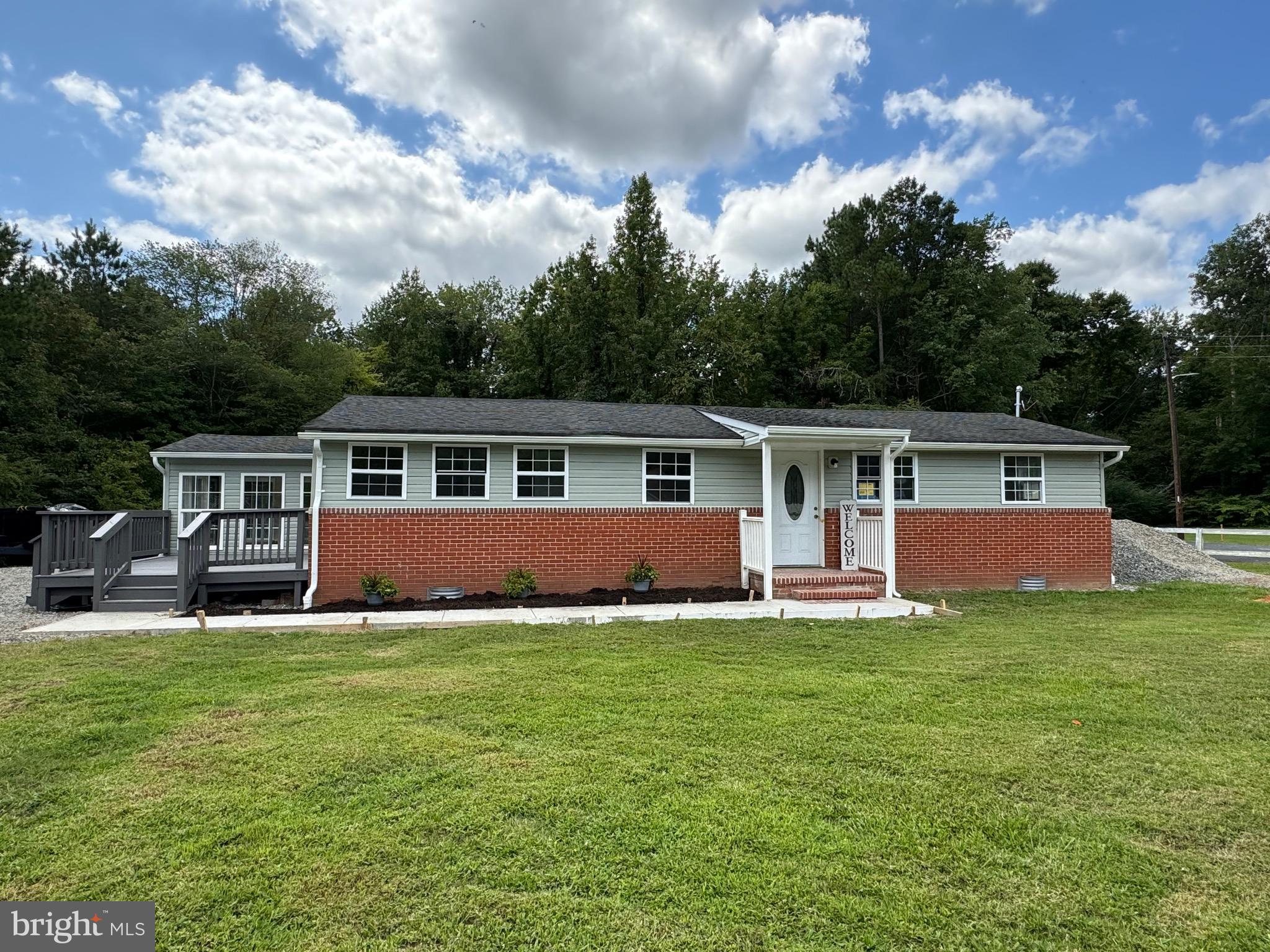 a front view of a house with a yard and trees