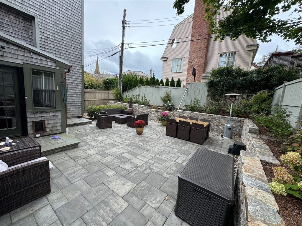 a view of a patio with couches table and chairs and potted plants