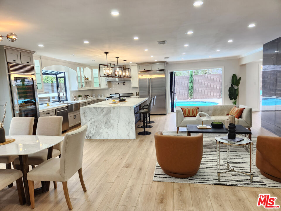 a living room with furniture and a dining table with kitchen view