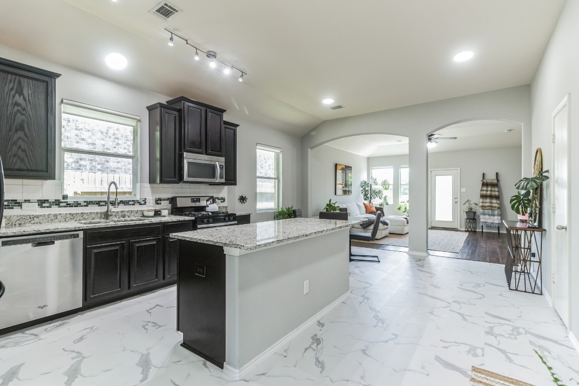 Prepare culinary delights in the spacious kitchen, featuring a center island and ample granite countertops for meal prep.
