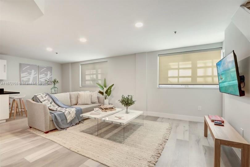 a living room with furniture window and a flat screen tv