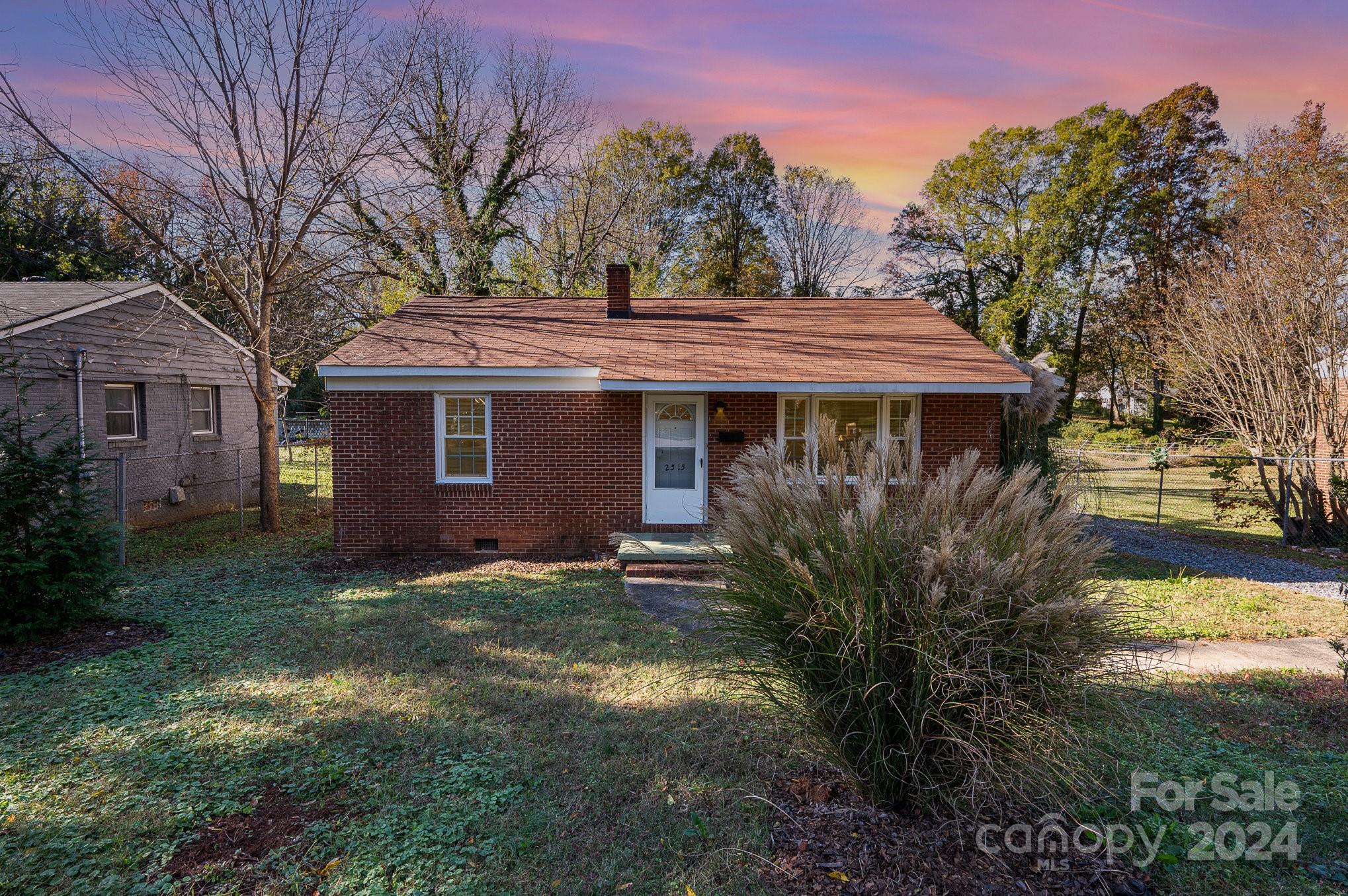 a front view of a house with yard and tree s