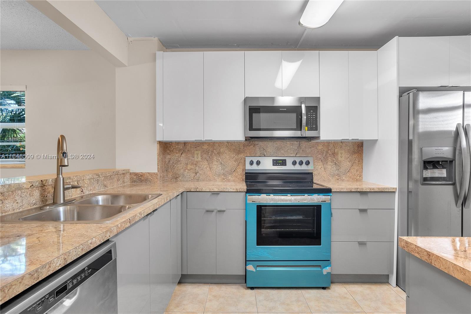 a kitchen with granite countertop a sink stove and refrigerator