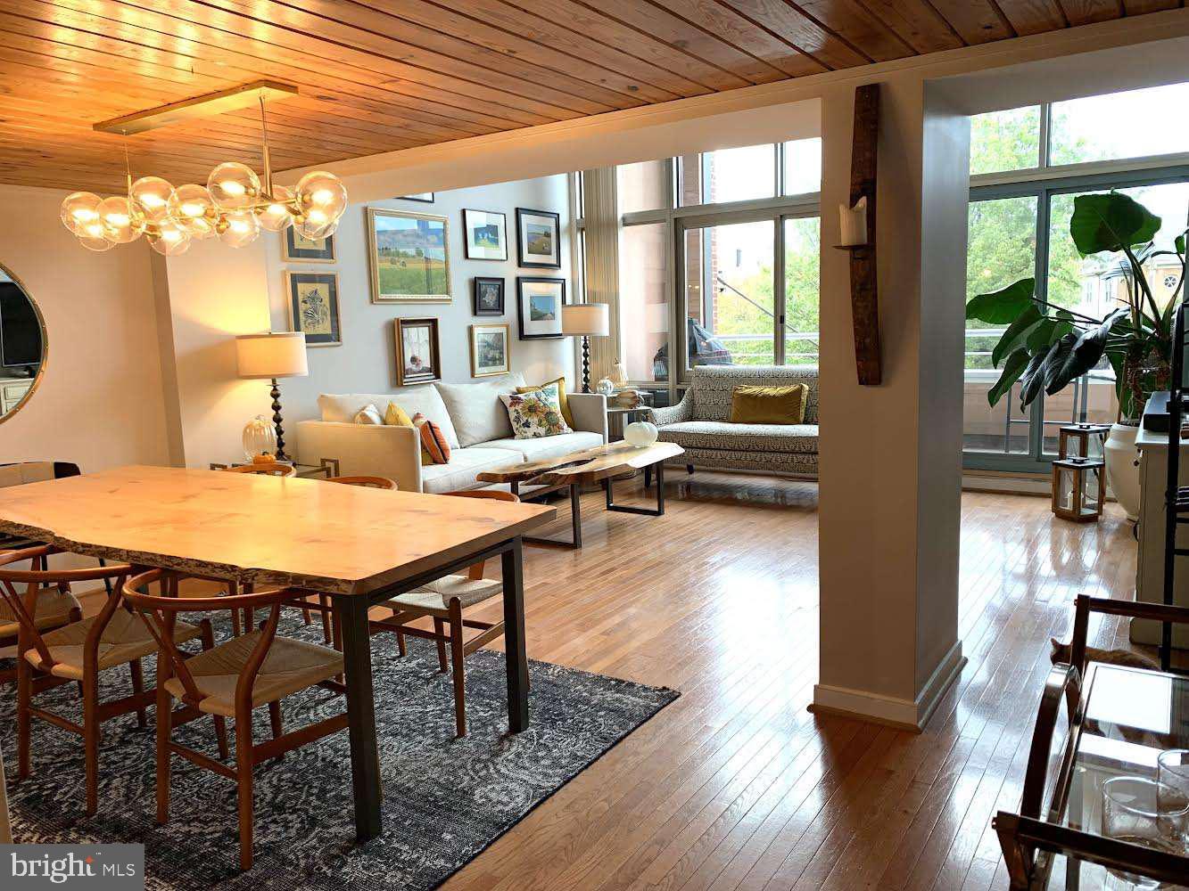 a living room with furniture a large window and wooden floor