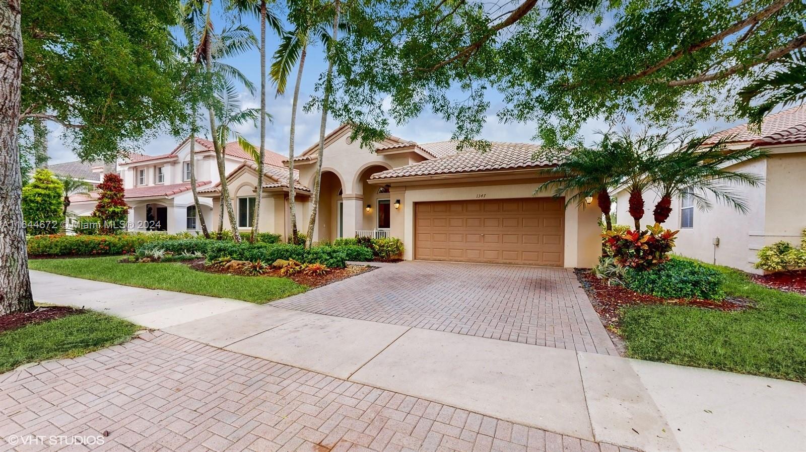 a front view of a house with a garden and plants