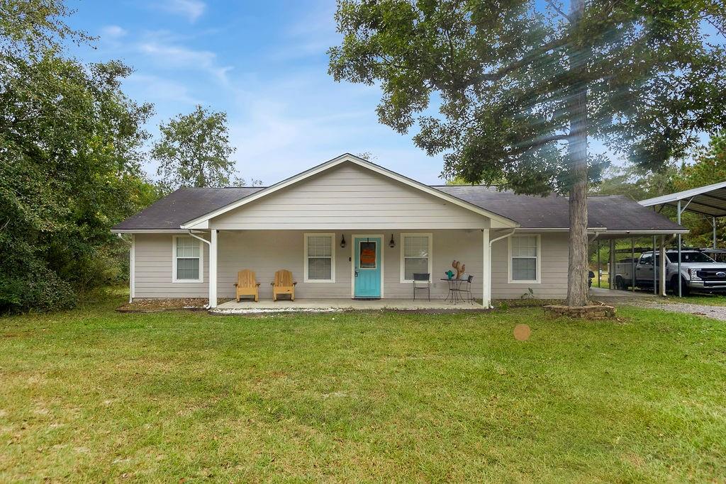 a view of a house with a yard and sitting area