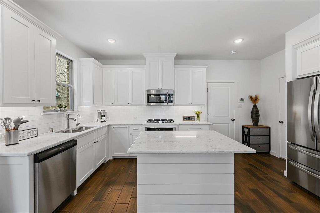 a kitchen with appliances a sink and cabinets