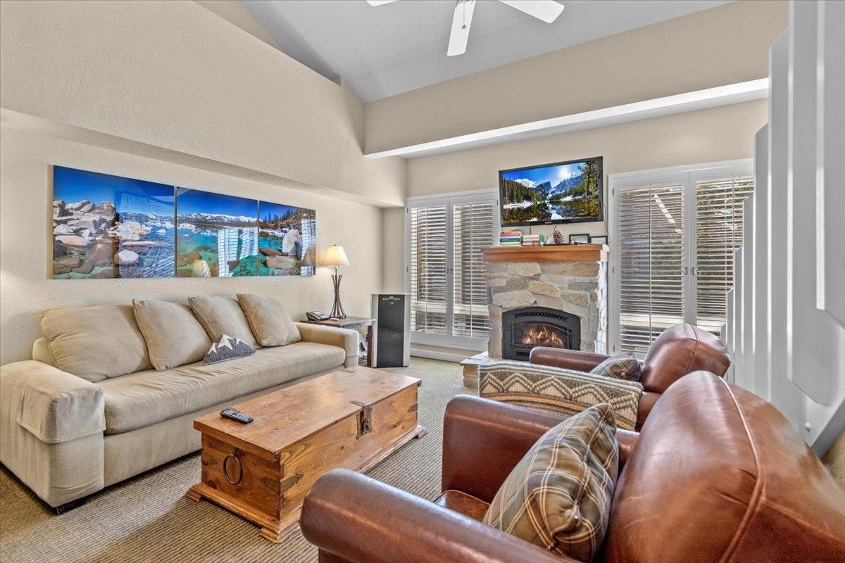 a living room with furniture a fireplace and a large window