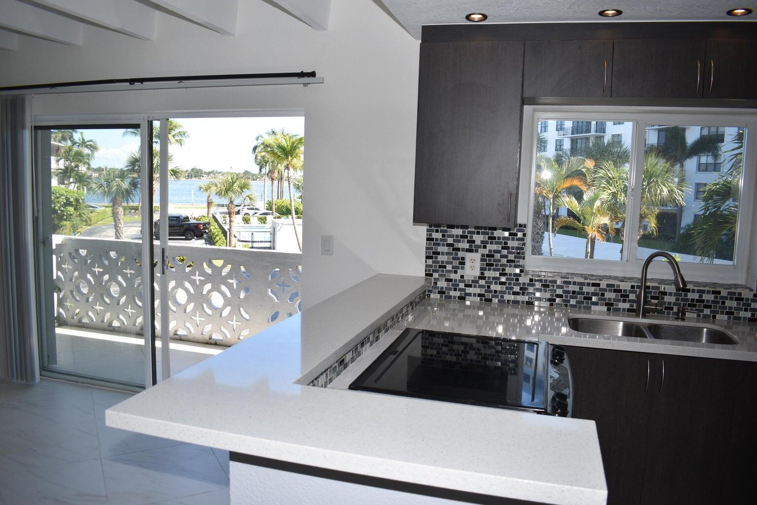 a view of a kitchen with a sink and large window