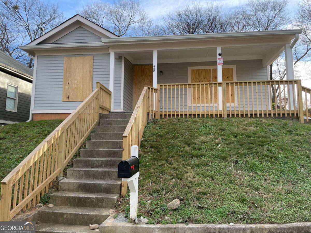 a view of a house with a small yard and wooden floor and fence