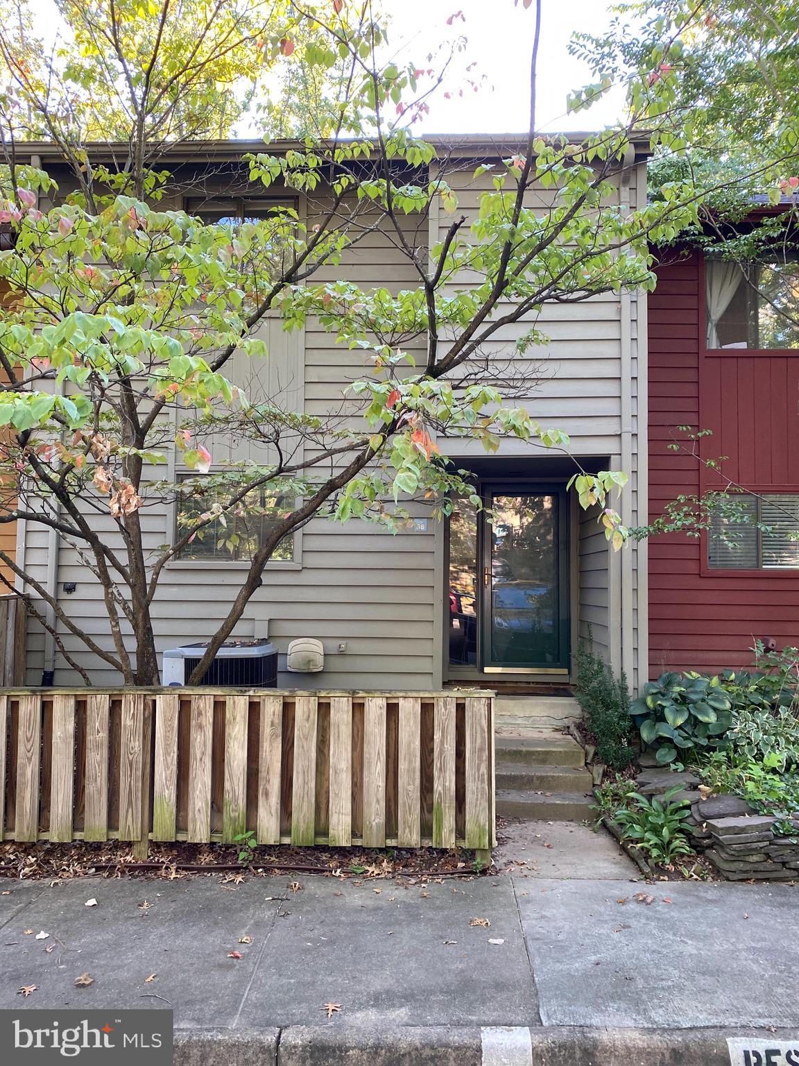 a front view of a house with a tree