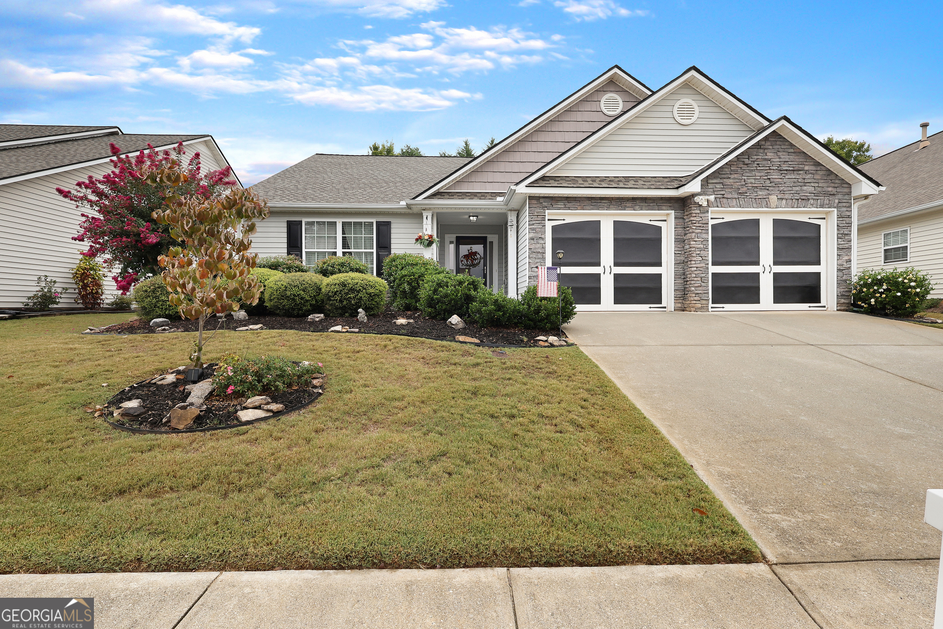 a front view of a house with a garden and yard