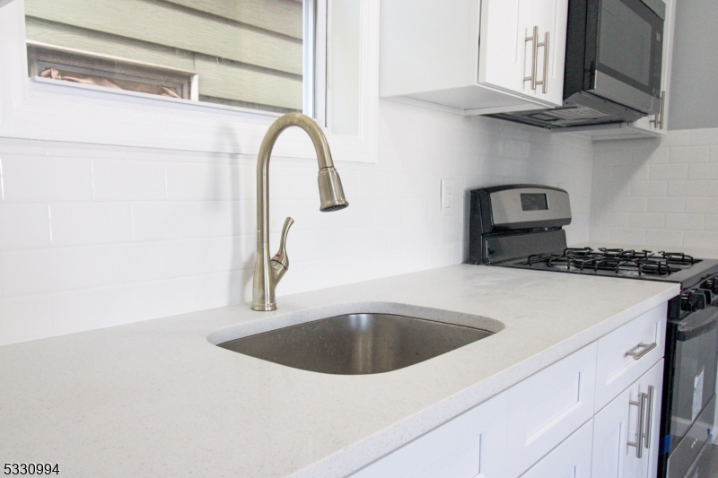 a kitchen with stainless steel appliances granite countertop a sink a stove and a refrigerator