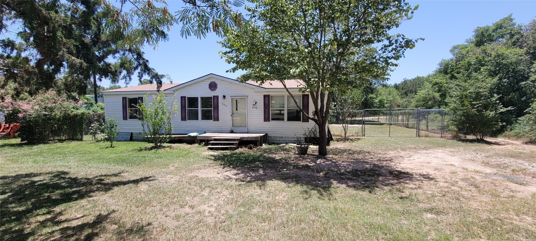 a view of backyard of house with green space