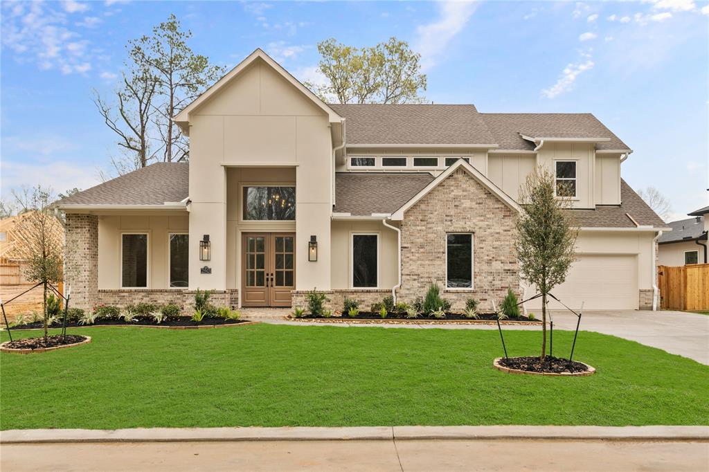 a front view of a house with a yard and green space