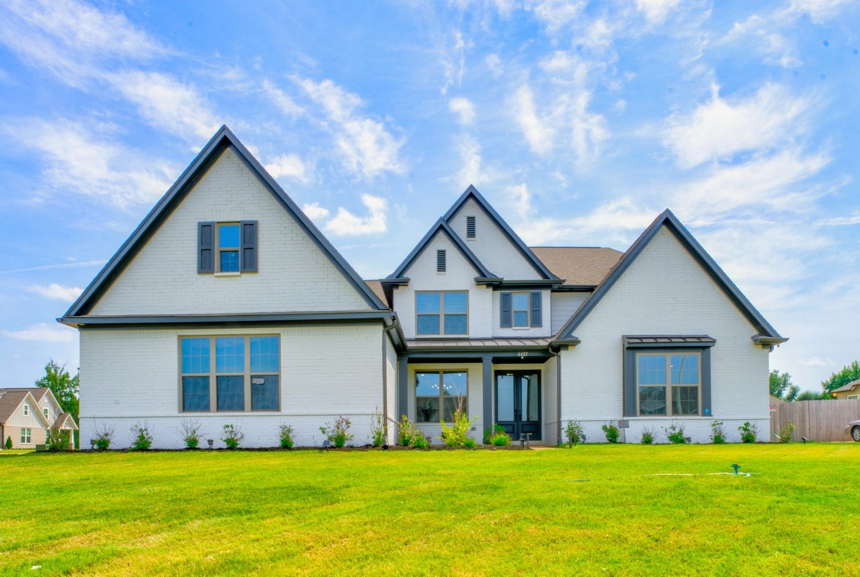 a front view of house with yard and green space