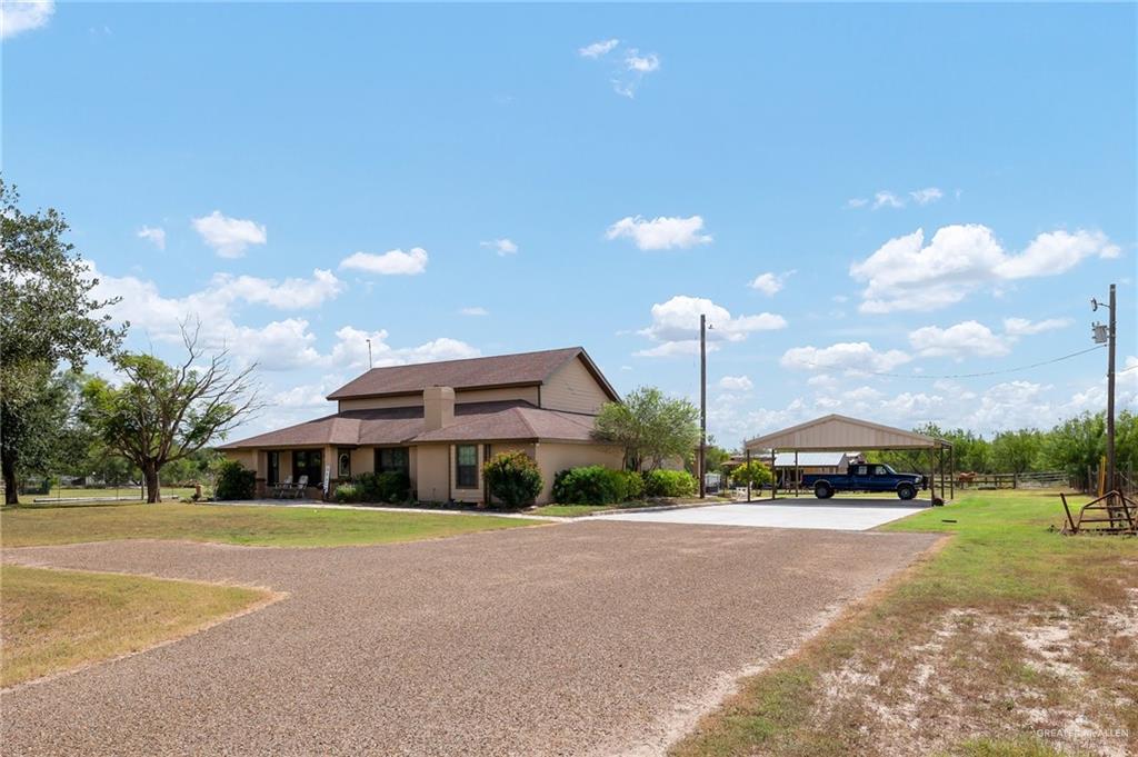 a front view of house with a yard and trees in the background