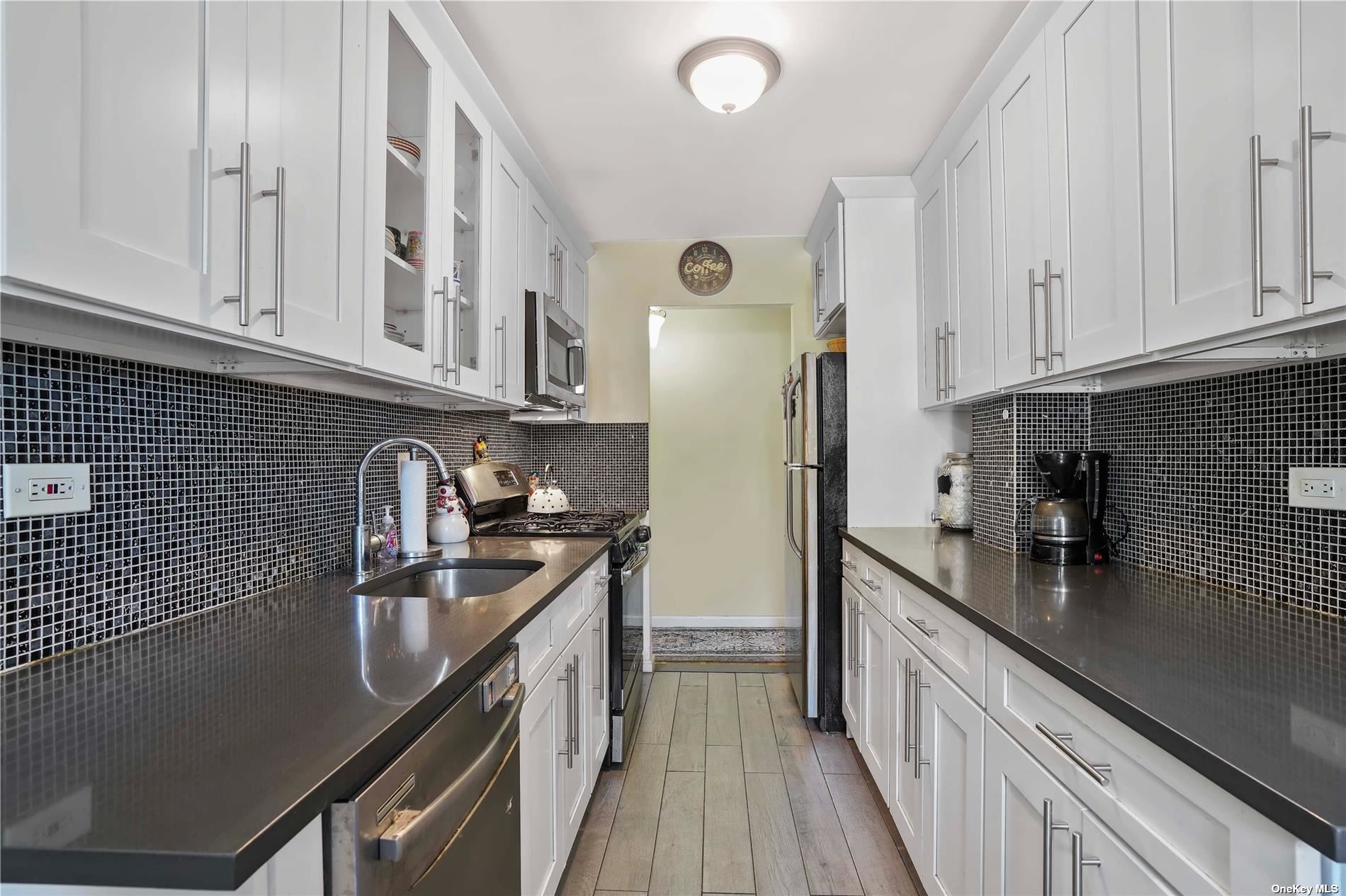 a kitchen with stainless steel appliances granite countertop a sink a stove and a refrigerator