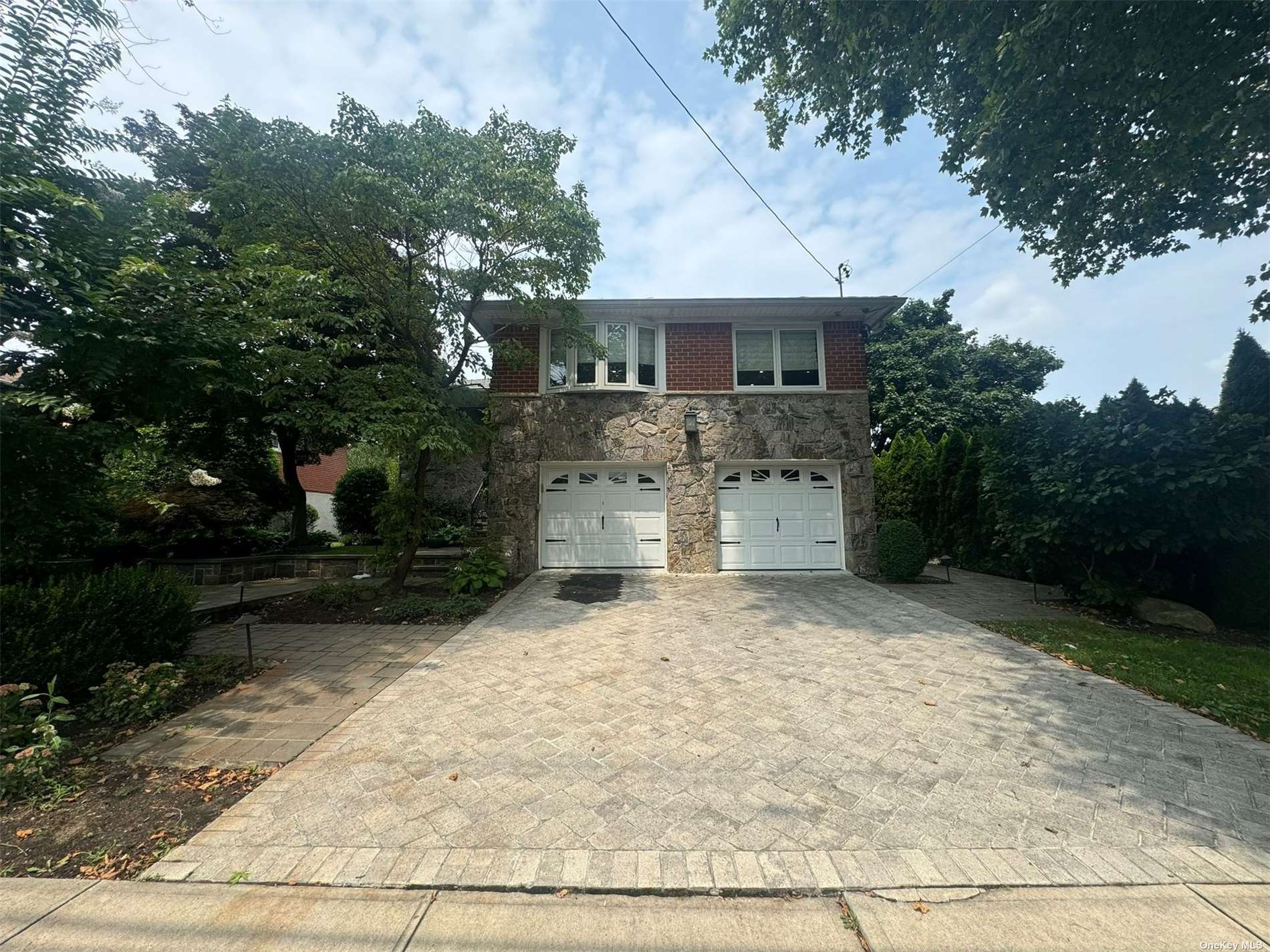 a front view of a house with a yard and trees