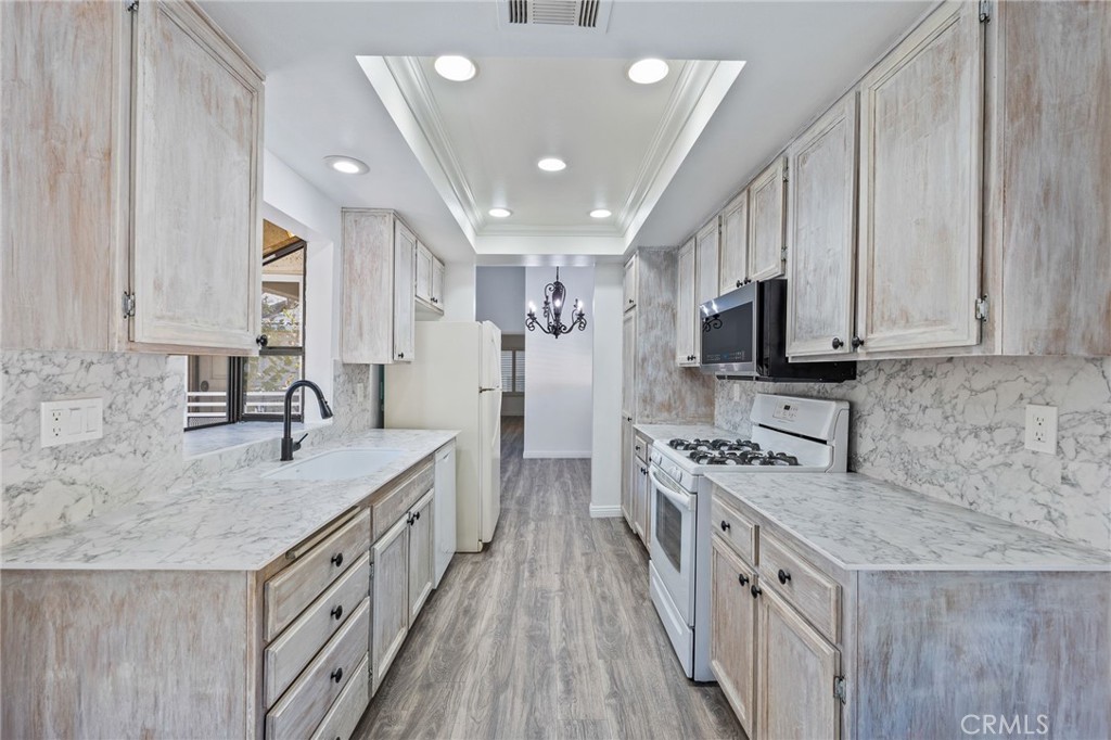 a kitchen with stainless steel appliances granite countertop a sink stove microwave and refrigerator