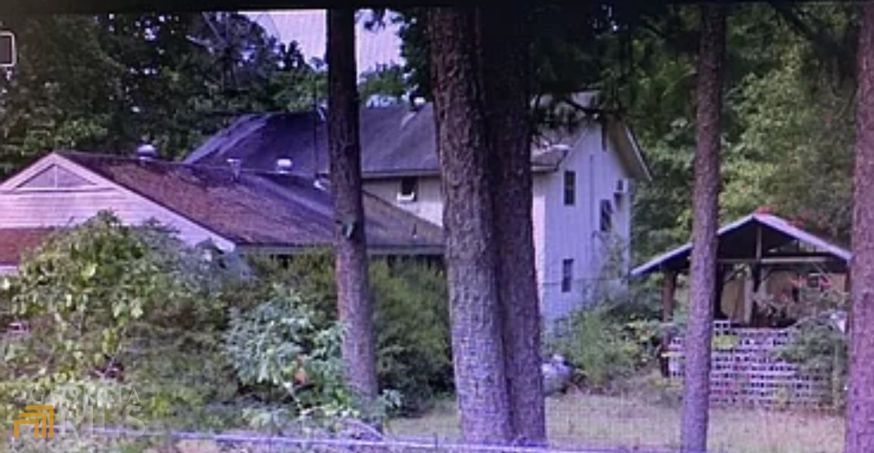 a view of a house with a yard and tree s