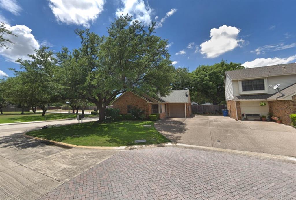 a view of a house with a yard and a large tree