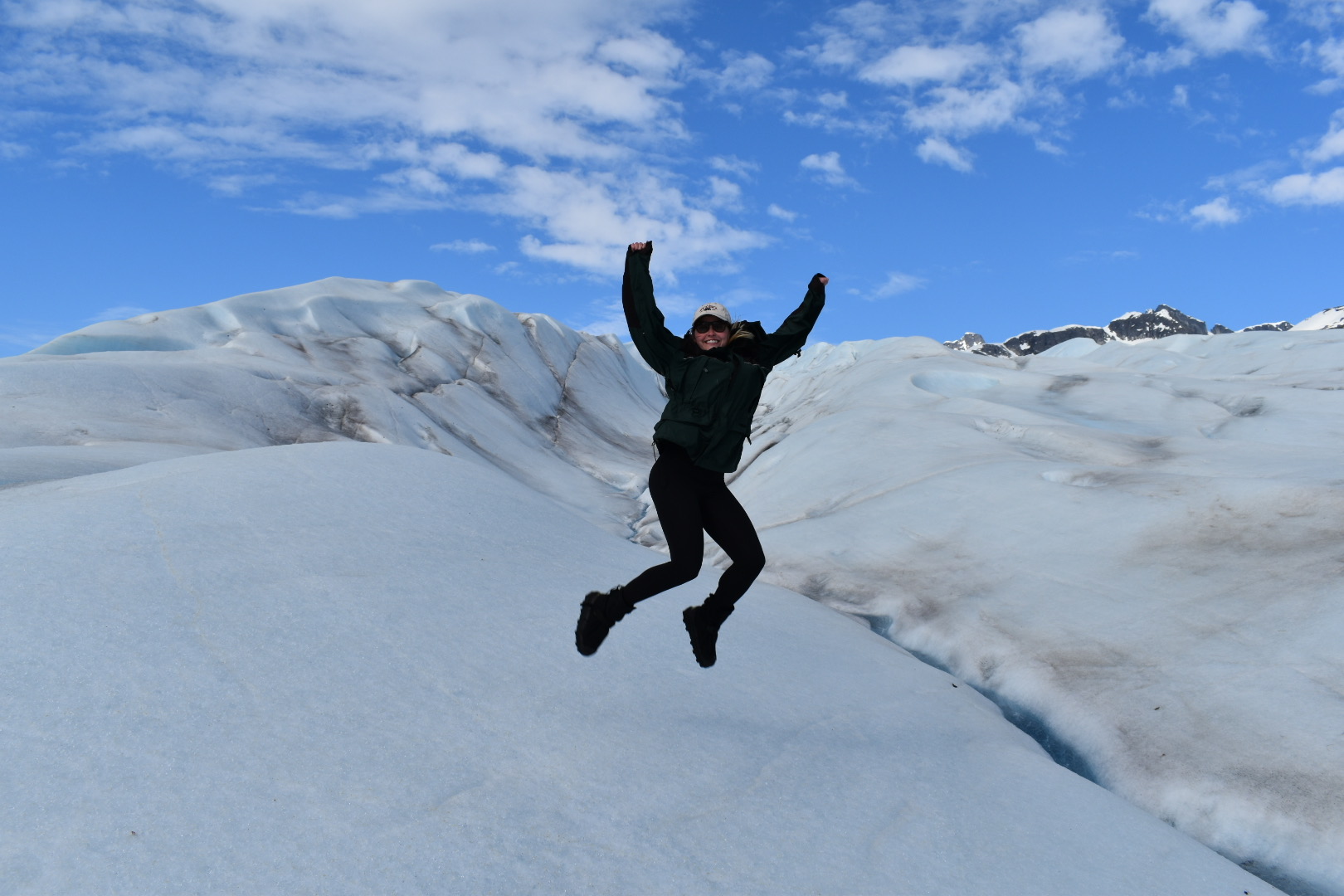 A man on a snowboard jumping over a snow covered slope