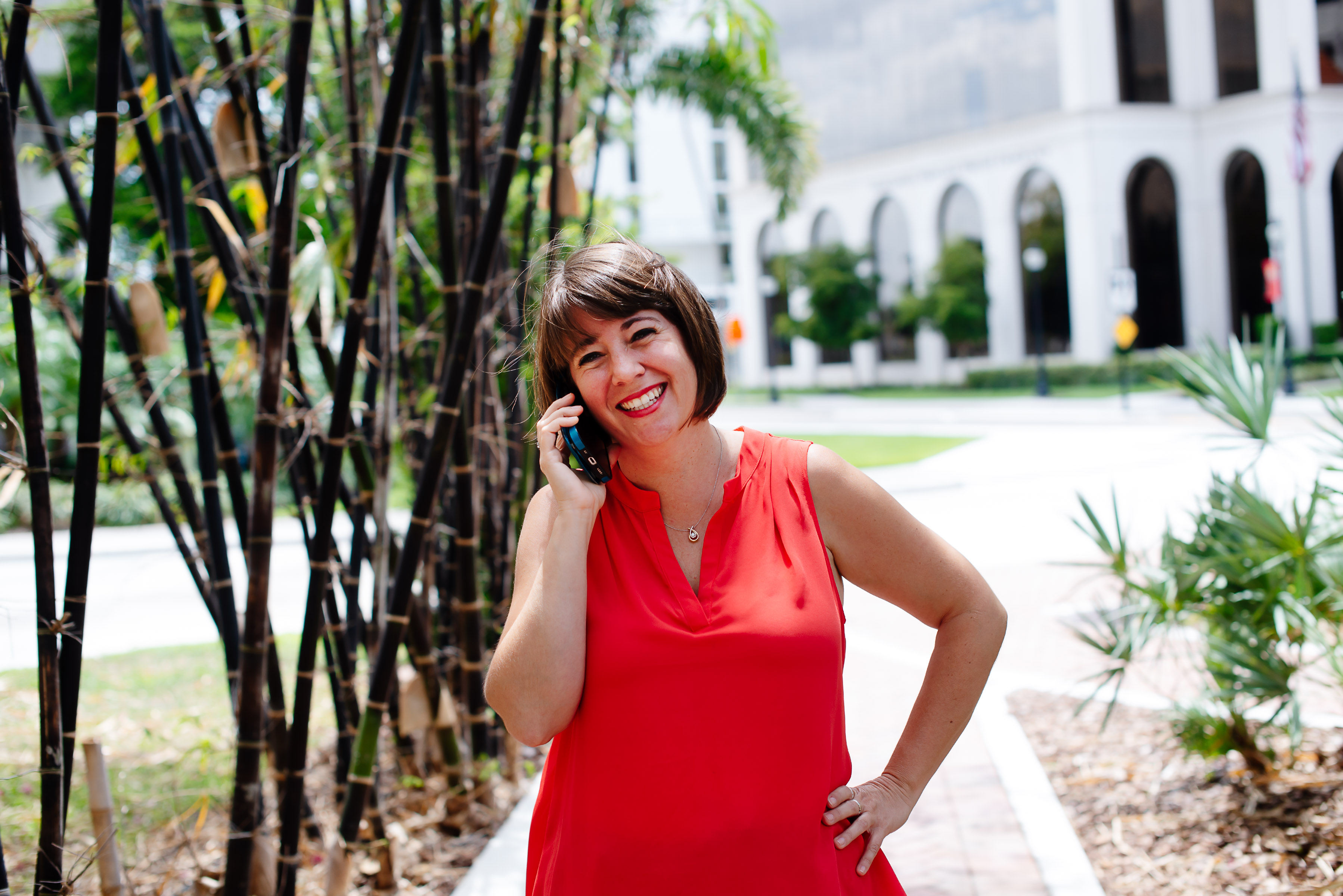 A woman in a red dress talking on a cell phone