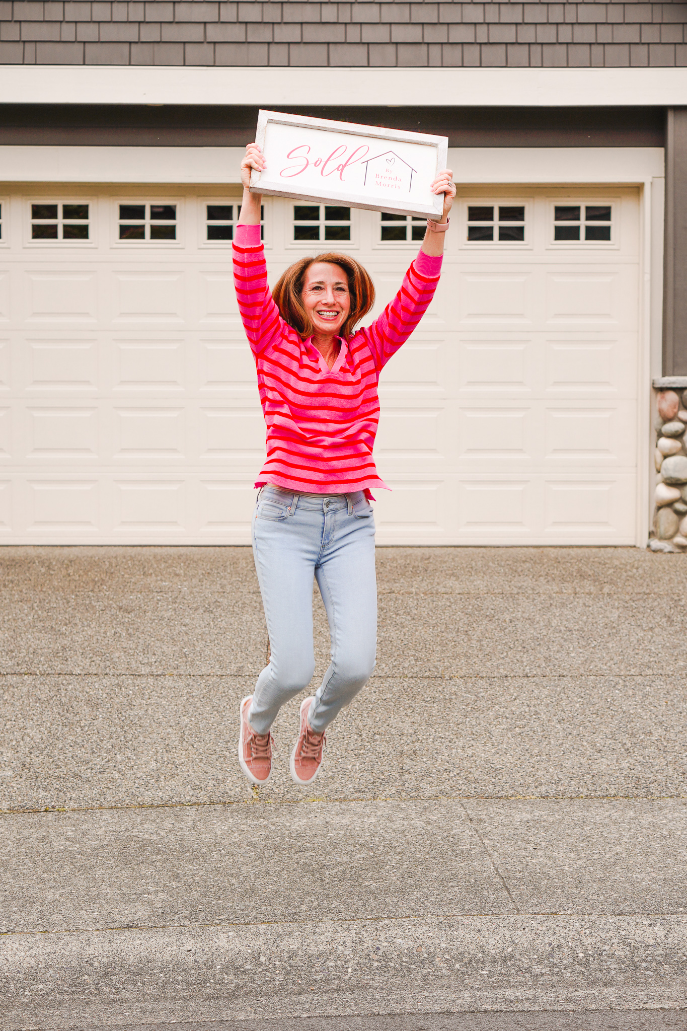 A woman in a red shirt jumping in the air.