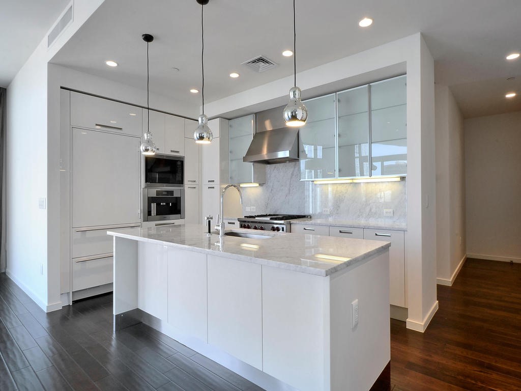 a kitchen with stainless steel appliances granite countertop a sink a stove and a wooden floors