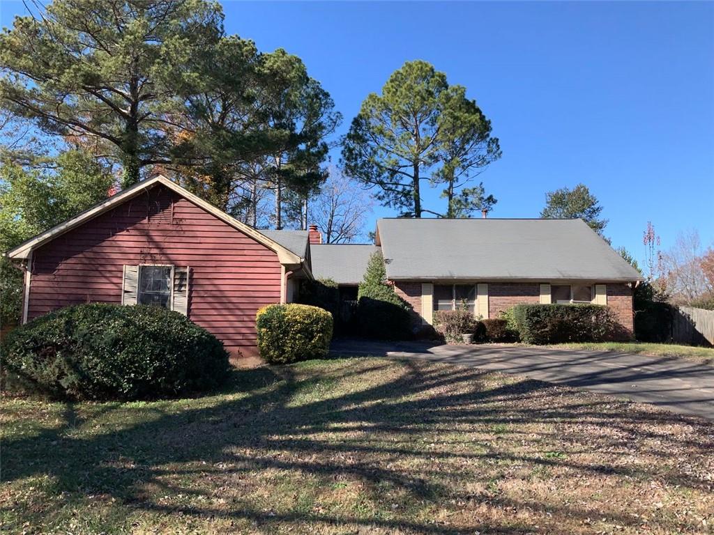 a front view of house with yard and trees in the background